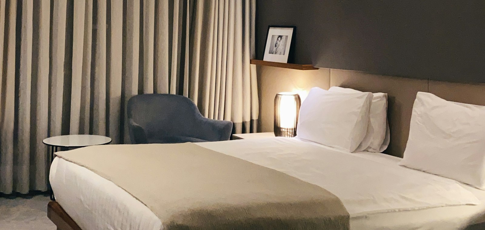 Otel odasında özenle hazırlanmış yatak ve konaklama alanı.